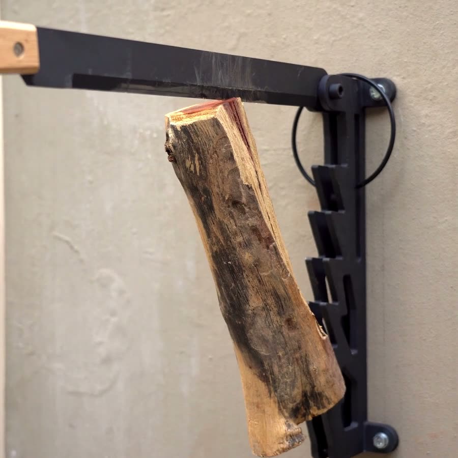BraaiPlank wall-mounted kindling splitter on the wall with a log loaded